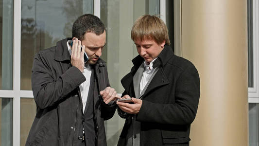 两位商人在电话和阅读信息上交谈