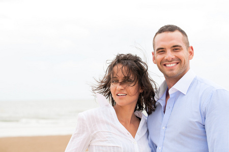 微笑着的年轻夫妇，在美丽的夏天海滩