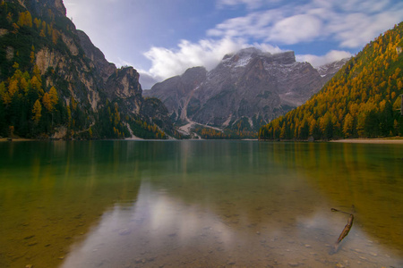 风景秀丽的 Braies 湖湖滨 Braies与秋天森林, 山和蓝色天空反射在表面湖水, 白云岩阿尔卑斯, 意大利