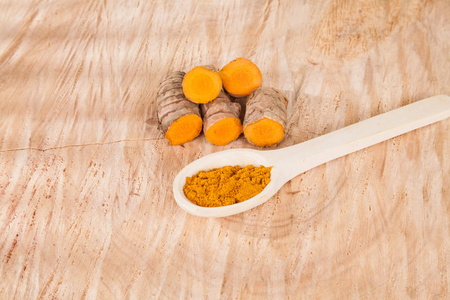 姜黄粉和新鲜姜黄在木背景