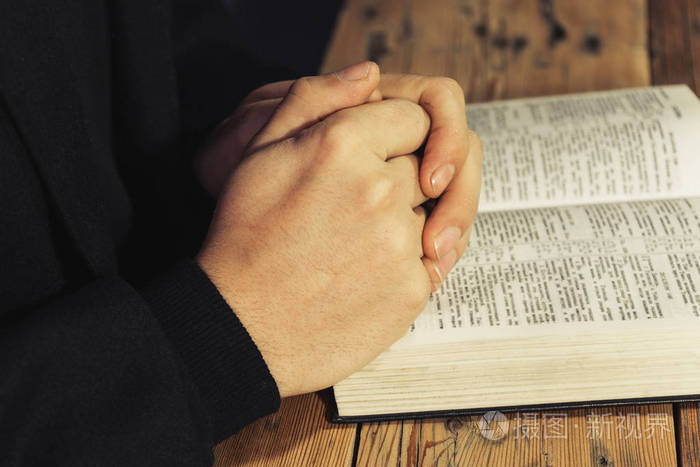 坐在老橡树桌上读圣经的人jpg