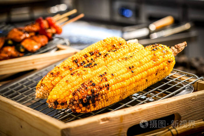 烤玉米在烧烤与模糊烧烤旁边