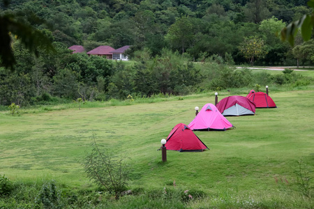 营地和帐篷在草坪上, 美丽的绿色自然景观的大坝水, 森林和山区在泰国