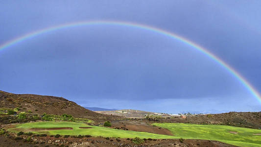 在西班牙大西洋岛上的 canari 上, 蓝天上的一条美丽多彩的彩虹照片