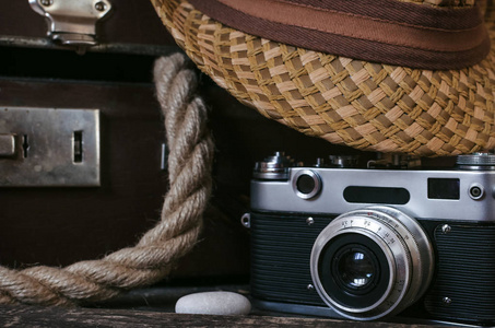 复古夏日海假期背景。古董手提箱, 绳子, 电影照片相机, 帽子和鹅卵石在旅游桌上。前视图, 特写照片