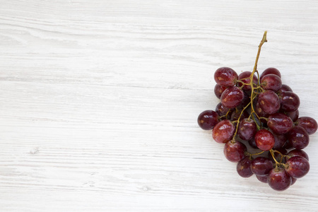 一束成熟的红葡萄在白色的木质背景上, 顶部视图。复制空间