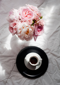 美平躺在咖啡和花束的花玫瑰和介子