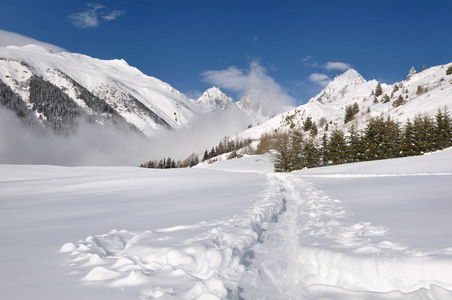 在高山山上穿越山谷的雪地里的足迹