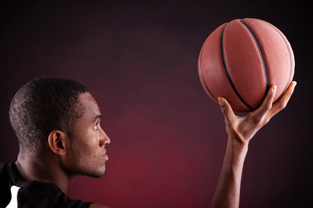 一个年轻男子篮球球员反对黑色表现力的肖像