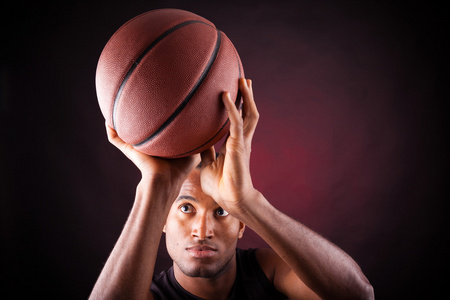 一个年轻男子篮球球员反对黑色表现力的肖像