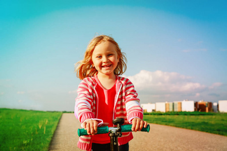夏天快乐的小女孩骑摩托车