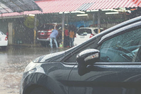 洗完车后, 雨点落在深蓝色的汽车上