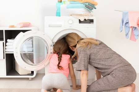 家庭主妇与小女儿洗衣服