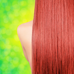 绿色散景背景上的直长红头发照片