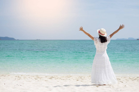 一个美丽的无忧无虑的女人在海滩上放松享受她的太阳衣服自由穿照片