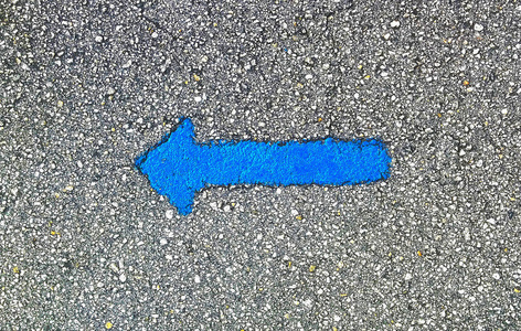 在公共街道上的交通 directionon 的沥青上涂上蓝色箭头