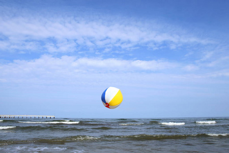 五颜六色的海滩球在飞行在海。假日海滩球在天空在海背景