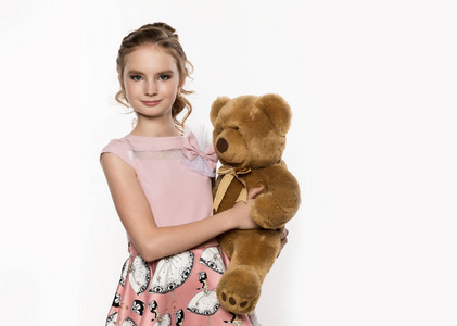 小女孩抱着一个白色的背景泰迪熊。文本的可用空间