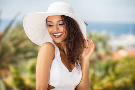 年轻非洲裔美国女孩的美丽肖像与非洲的发型在夏季帽子。微笑美丽的女人。度假理念