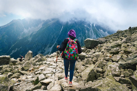 旅行和背包生活的概念。妇女旅行者用背包和追踪棍子在山顶。Rysy 山, Tatras, 斯洛伐克