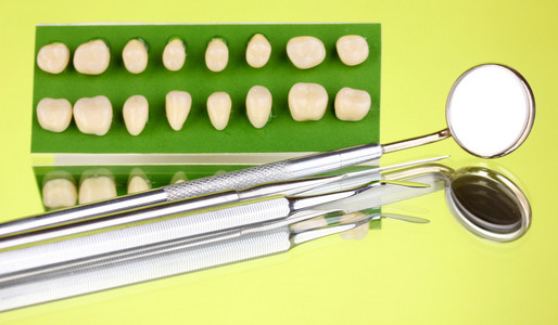 在绿色背景上的义齿的牙科工具设置