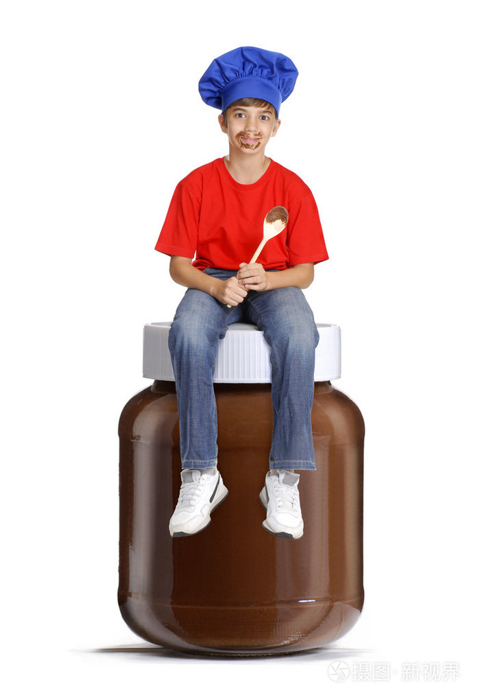 厨师小孩坐在一个巧克力锅,小孩拿着巧克力的匙子,孩子吃巧克力冰淇淋