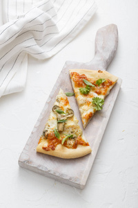 白色切割板上的两块奶酪比萨