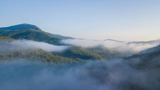 壮观的空中飞行通过山云彩在日出美丽的早晨。巅峰激励的动机自然背景