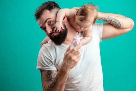 顽皮的父亲背着他的微笑婴儿的脖子上的蓝色背景