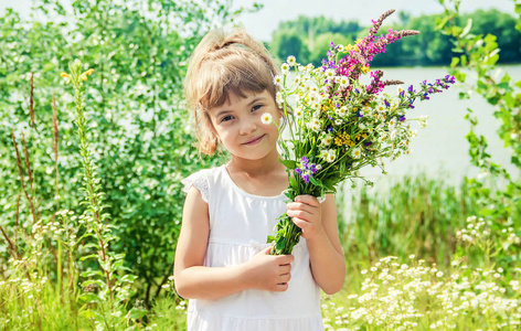 孩子带着一束野花。选择性对焦。自然