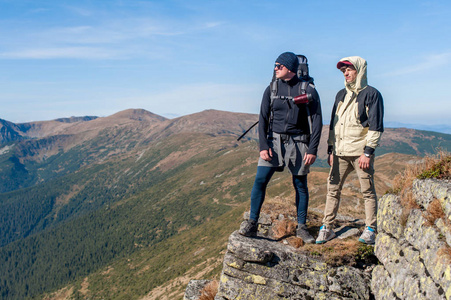 两个冒险家站在悬崖的边缘, 并期待着乌克兰的巨大山脉