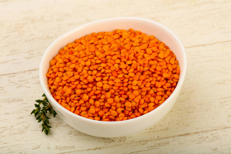 在木制的背景碗橙色小扁豆照片