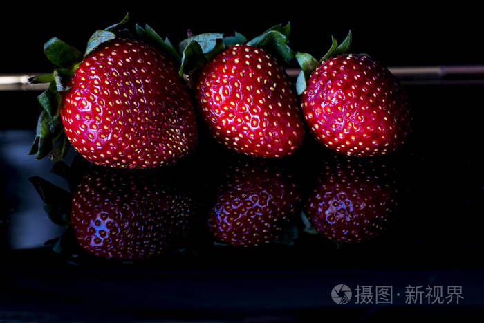 三草莓在黑桌黑色背景