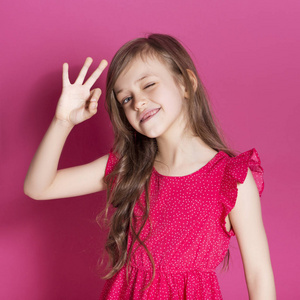 中性情绪8岁的小女孩在粉红色的中性背景下, 用手做一些情绪化的手势.