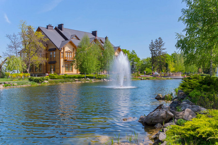 公园区域与一个大木房子, 湖和喷泉在它。Mezhigorye, 乌克兰