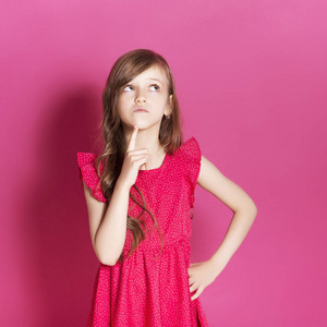 8岁的小女孩在粉红色的中性背景下, 用手做一些情绪化的手势.