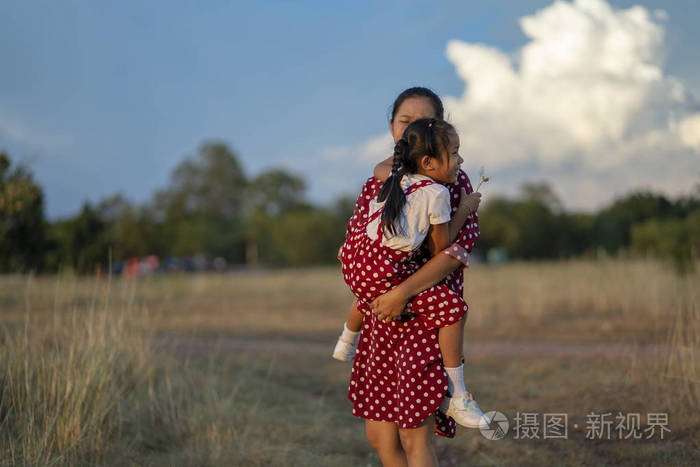母亲在草坪上愉快地拥抱女儿