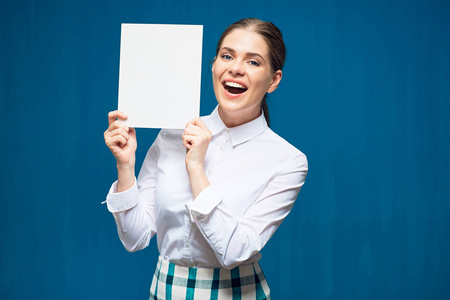 蓝色背景的微笑的妇女穿着白色衬衣持有广告牌板