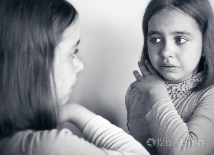 少女哭着看着镜子里的倒影