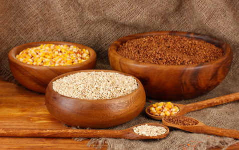 原料玉米 荞麦 小麦的木碗上麻布背景表格