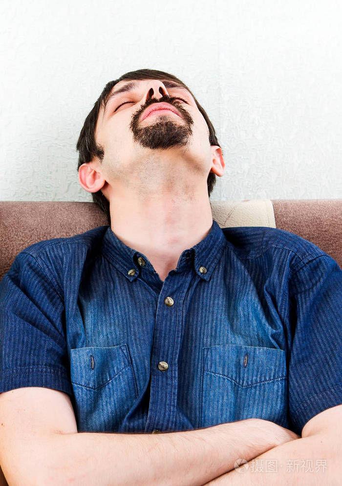 疲惫的男人坐在沙发上睡在家里