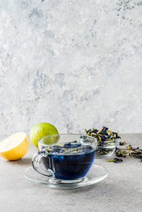 健康饮品, 有机蓝蝶豌豆茶配以石灰和柠檬, 灰色混凝土背景复制空间
