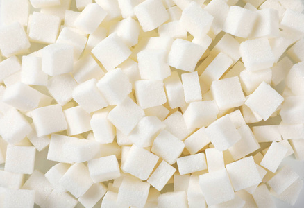 糖立方体和糖的背景. 黑背景上的白糖.