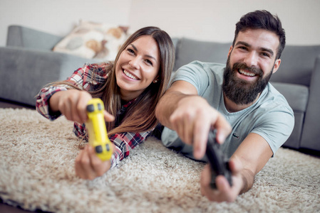 年轻夫妇玩电子游戏, 笑着一起笑