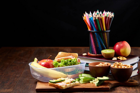 学校午餐休息的概念与健康的午餐盒和学校用品在木桌上, 选择性重点
