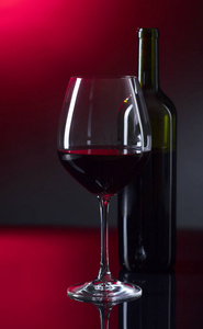 玻璃和瓶红酒，带黑色的反光背景