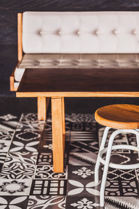 现代木制家具的地板上有黑白装饰瓷砖。椅子, 桌子, 沙发