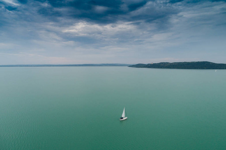 白色帆船在巴拉顿湖湖与云彩天空