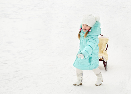 在冬季天拉她雪橇的小女孩