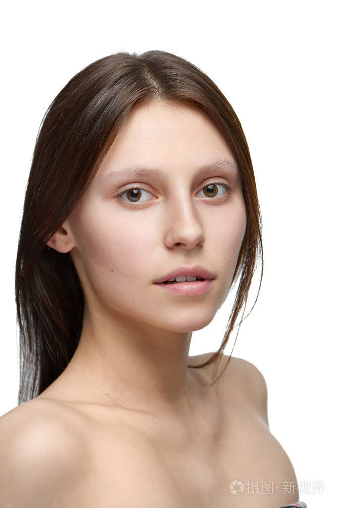 没有化妆的女孩的肖像看着相机